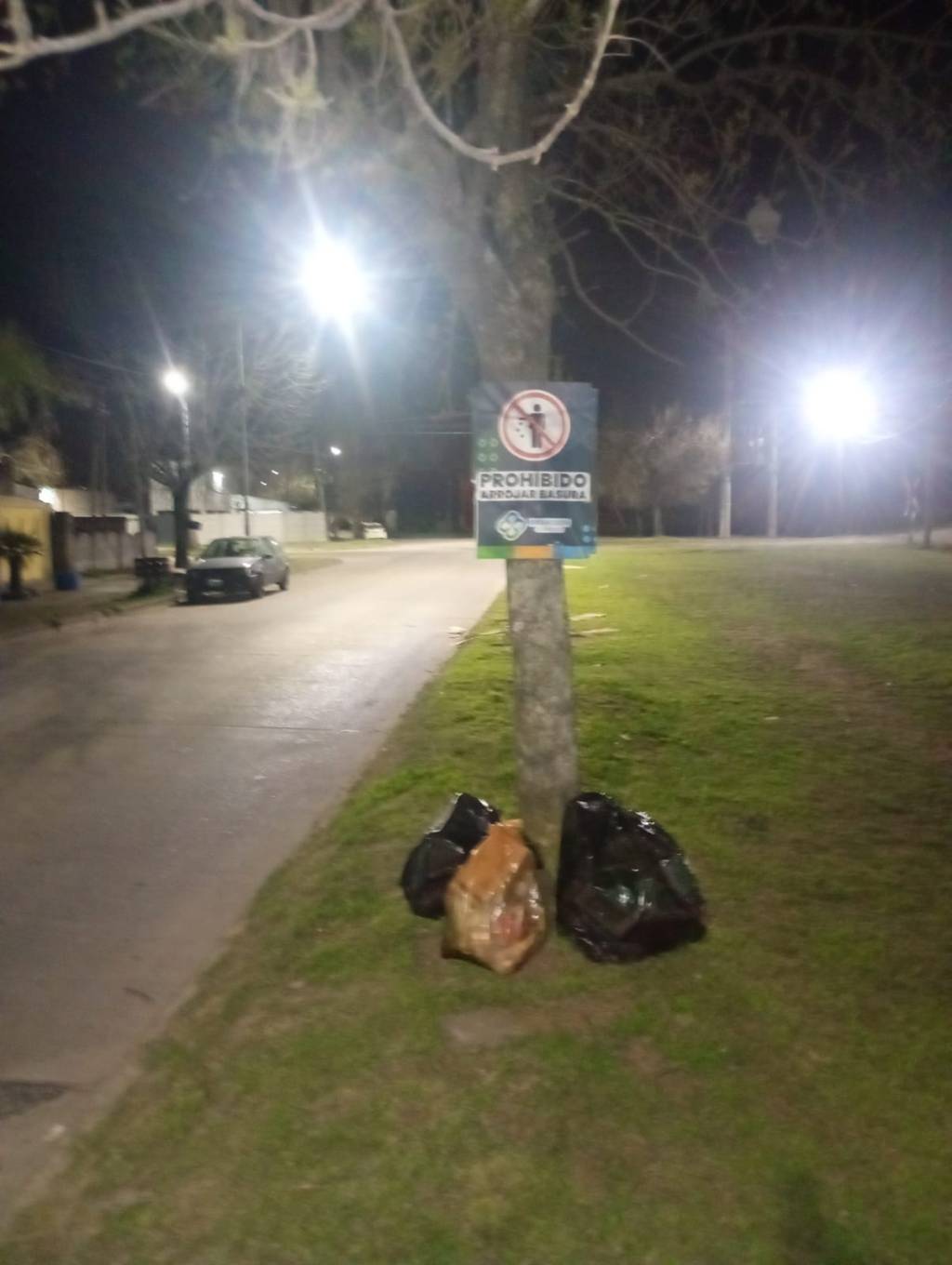 ARROJAN BOLSAS DE BASURA BAJO UN CARTEL QUE INDICA QUE ESTÁ PROHIBIDO